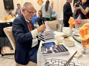 R. A. Ramirez-Baez Signing His Book for Guest.